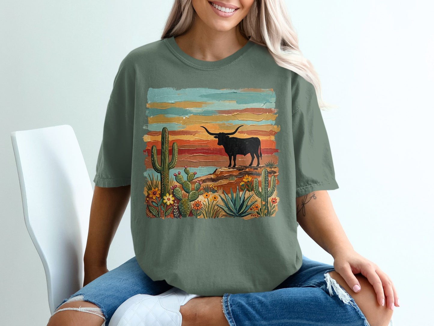 Green t-shirt with desert scene featuring a bull and cacti.