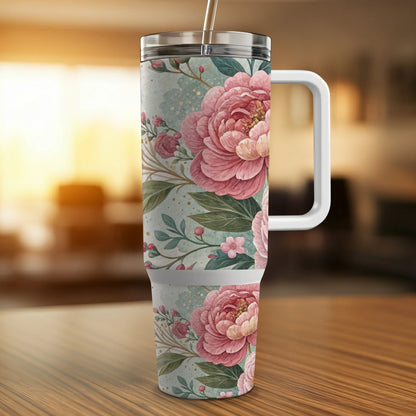 Pink peonies and floral pattern on a tall tumbler with white handle.