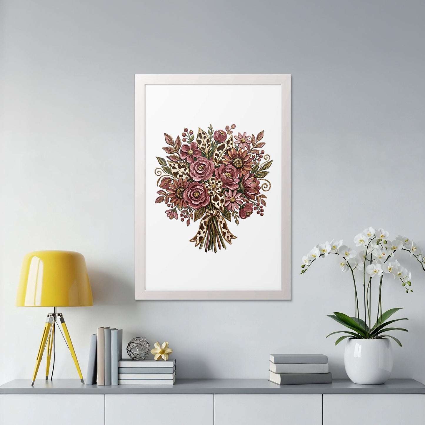 Framed floral bouquet art with yellow lamp and white orchid plant.