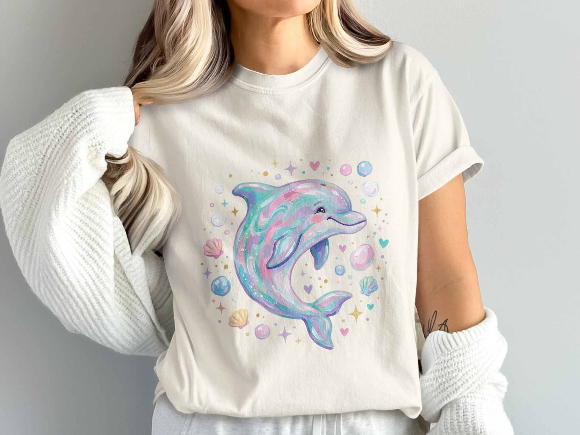 Cream t-shirt with a pastel dolphin, shells, and hearts graphic.