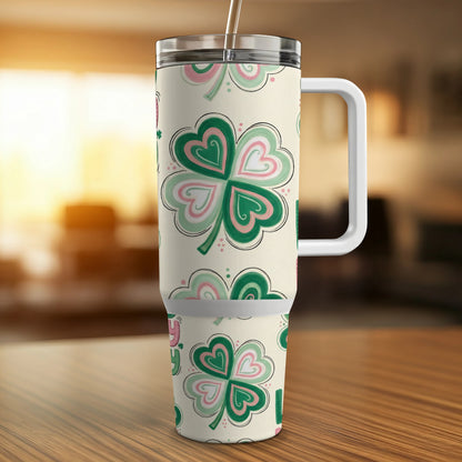 Cream tumbler with shamrock pattern and white handle.