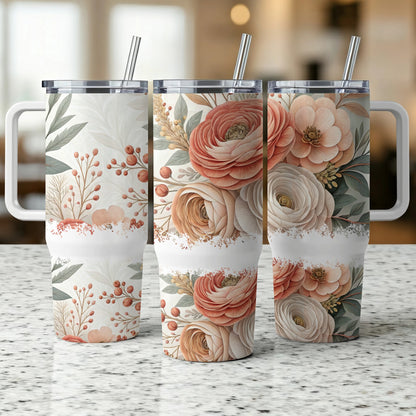 Three floral patterned tumblers with handles and straws displayed on a counter.