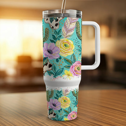 Turquoise tumbler with cowboy boot, cactus, and feather floral pattern.