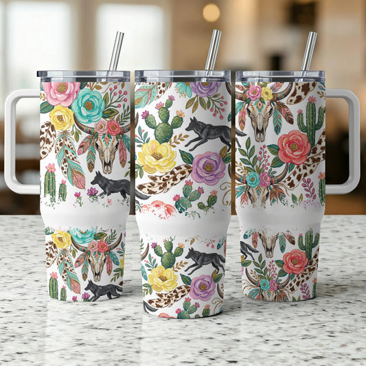 Three tumblers with floral, wolf, and skull designs, displayed on a counter.