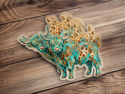 Two decorative highland cow stickers with turquoise and gold spots on wood.