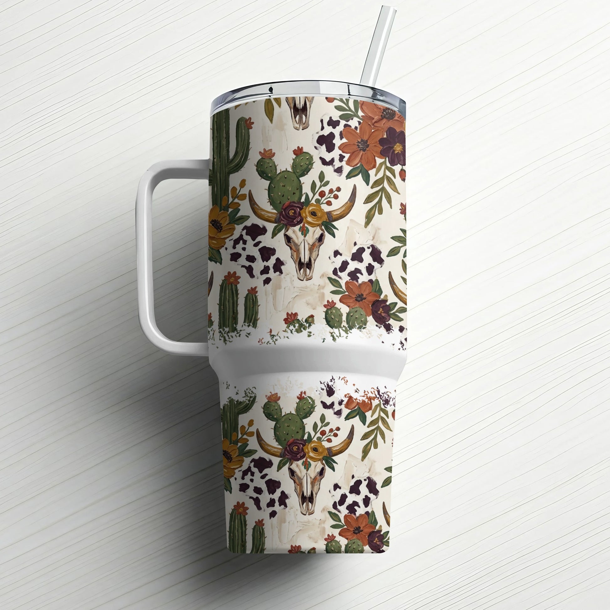 White tumbler with a rustic desert skull and floral pattern, featuring a straw.