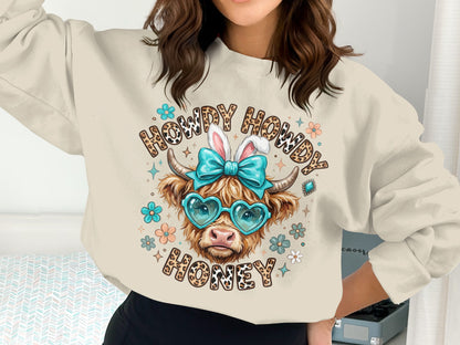 Cow wearing heart sunglasses and bunny ears on "Howdy Howdy Honey" sweatshirt.