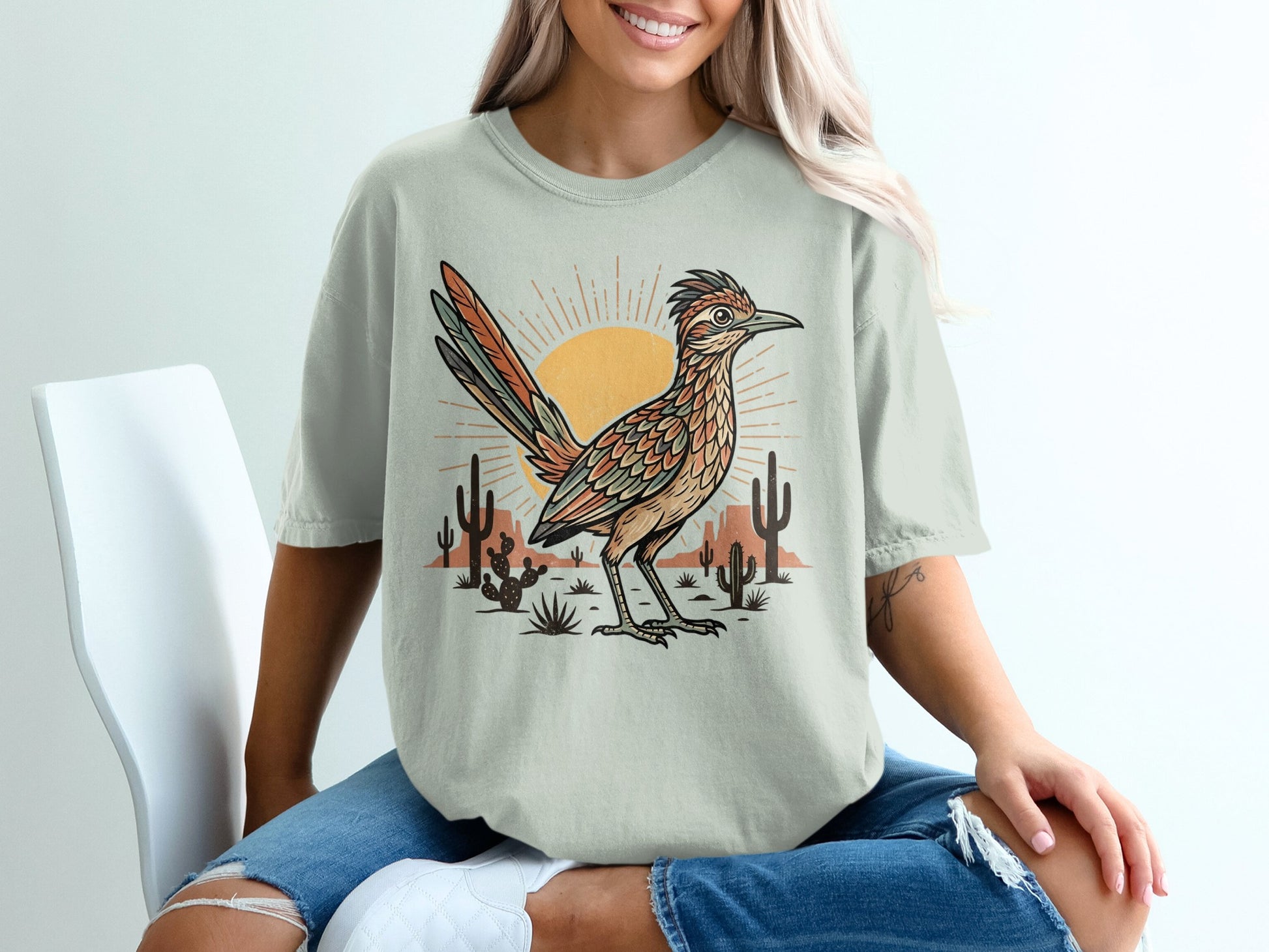 T-shirt graphic featuring a roadrunner bird, desert cacti, and sun.