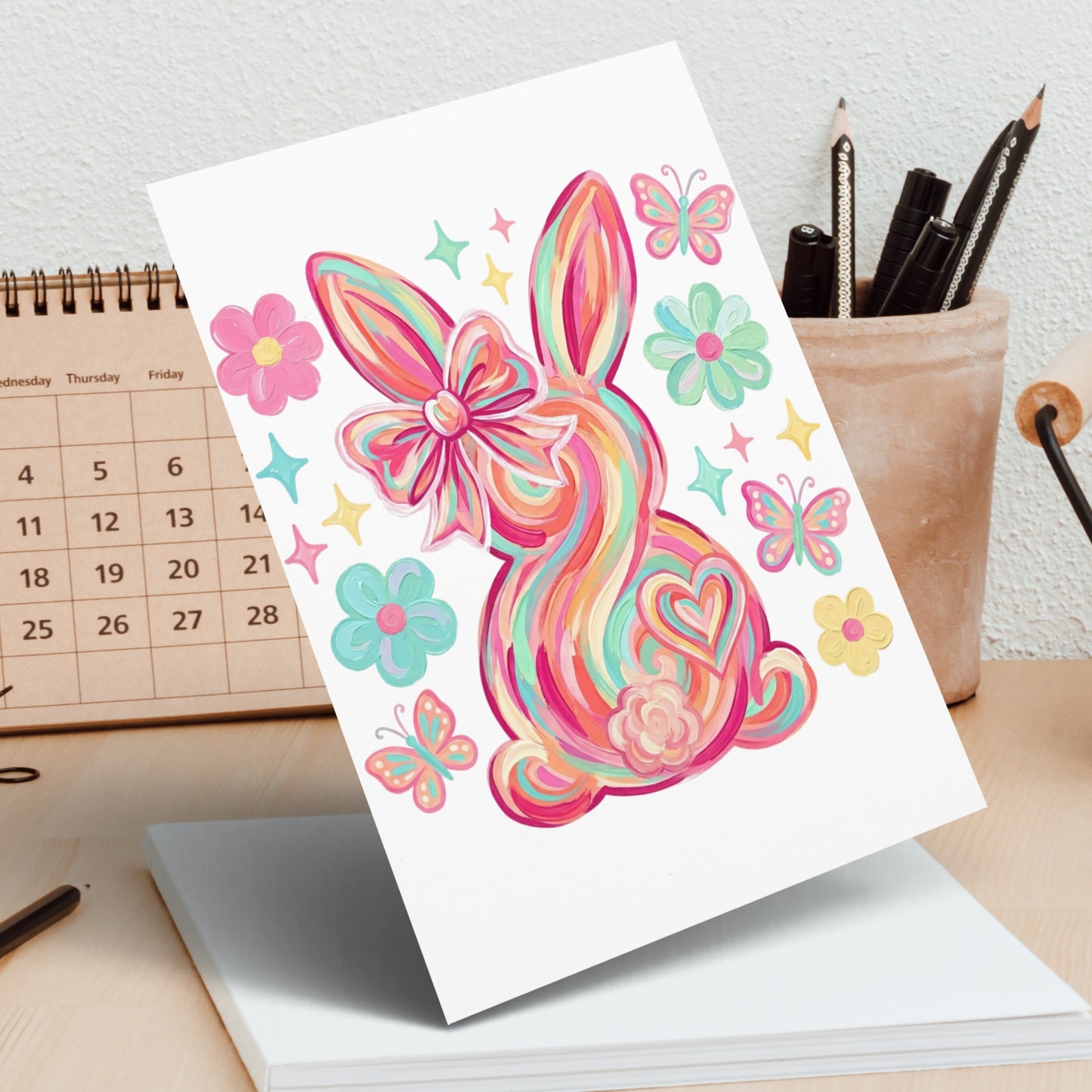 Colorful striped Easter bunny with a bow and butterflies on a calendar.