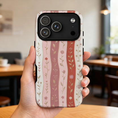 Woman's hand holding iPhone 14 Pro with floral wavy stripe pattern.