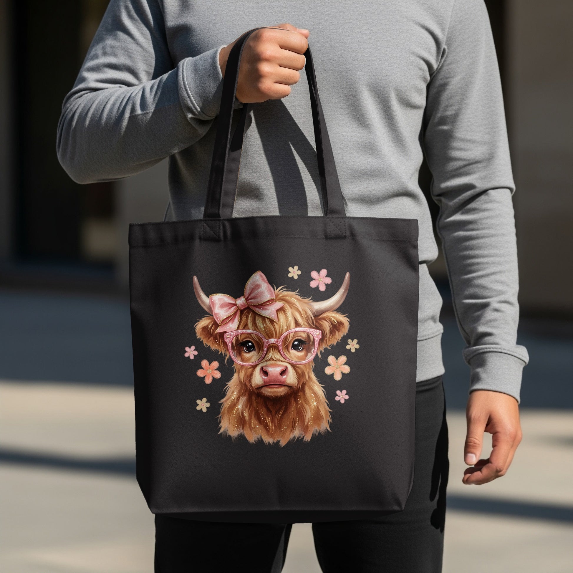 Black tote bag with a Highland cow graphic wearing glasses and a bow.