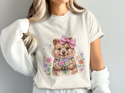 Watercolor illustration of a smiling bear holding a bouquet of flowers with a pink bow.