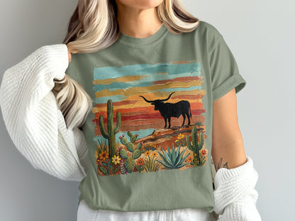 Green t-shirt with a desert landscape featuring a bull and cacti, painted in colorful stripes.