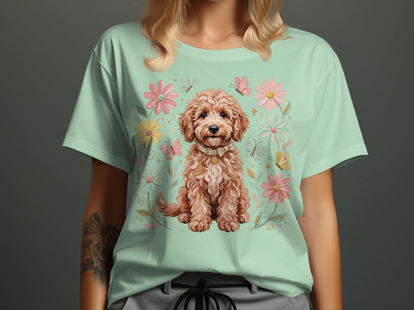 Light green t-shirt featuring a fluffy dog surrounded by flowers and butterflies.