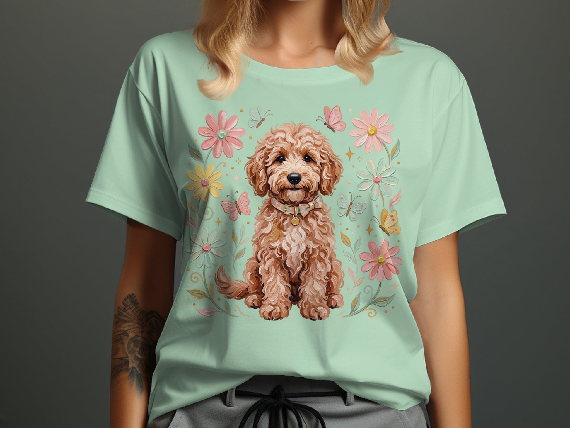 Light green t-shirt featuring a fluffy dog surrounded by flowers and butterflies.