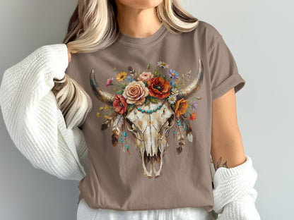 Brown t-shirt featuring a cow skull adorned with colorful flowers and feathers.