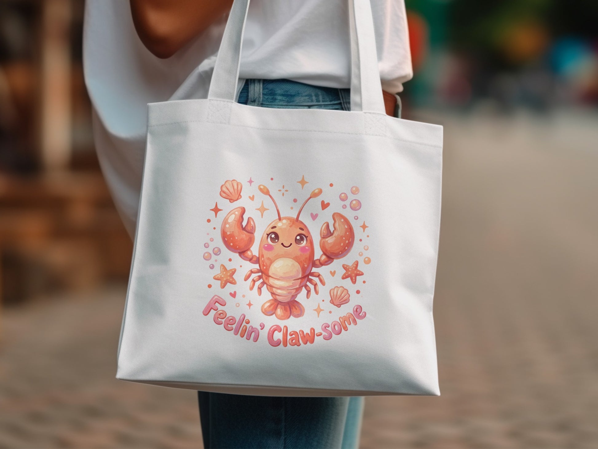 White canvas tote bag with a cheerful cartoon lobster and "Feelin' Claw-some" text.