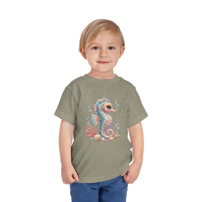 Toddler wearing grey t-shirt with a whimsical seahorse and coral graphic.