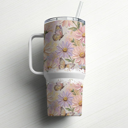 Floral tumbler with butterflies and straw, on a white wood surface.