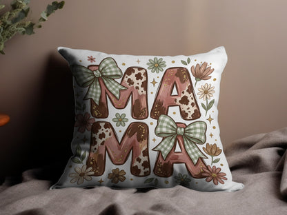 Pillow with "MAMA" text in cow print and floral design with green bows.