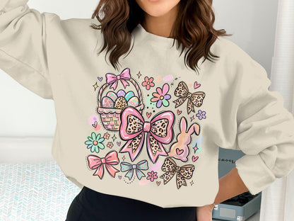 Cream sweatshirt with Easter-themed graphic: basket, eggs, bunny, bows, flowers.
