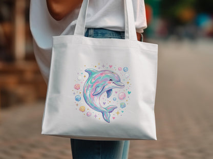 White canvas tote bag with iridescent dolphin and seashell illustration.