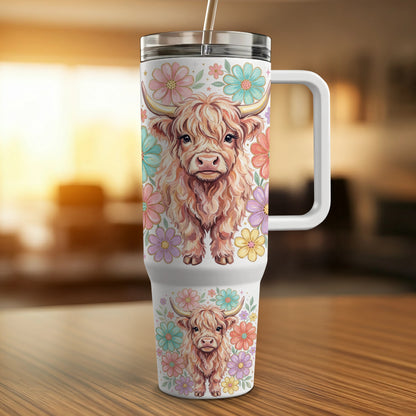 Highland cow and floral pattern on a white insulated tumbler with handle and straw.