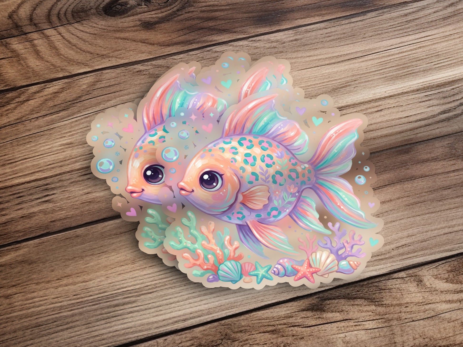 Two cartoon goldfish with pastel scales swimming among coral and seashells.
