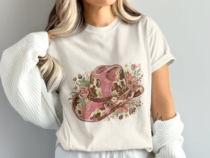 White t-shirt with a distressed pink cowboy hat graphic featuring floral accents.