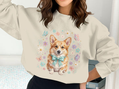 Cream sweatshirt with a Corgi wearing a blue bow and surrounded by flowers and butterflies.