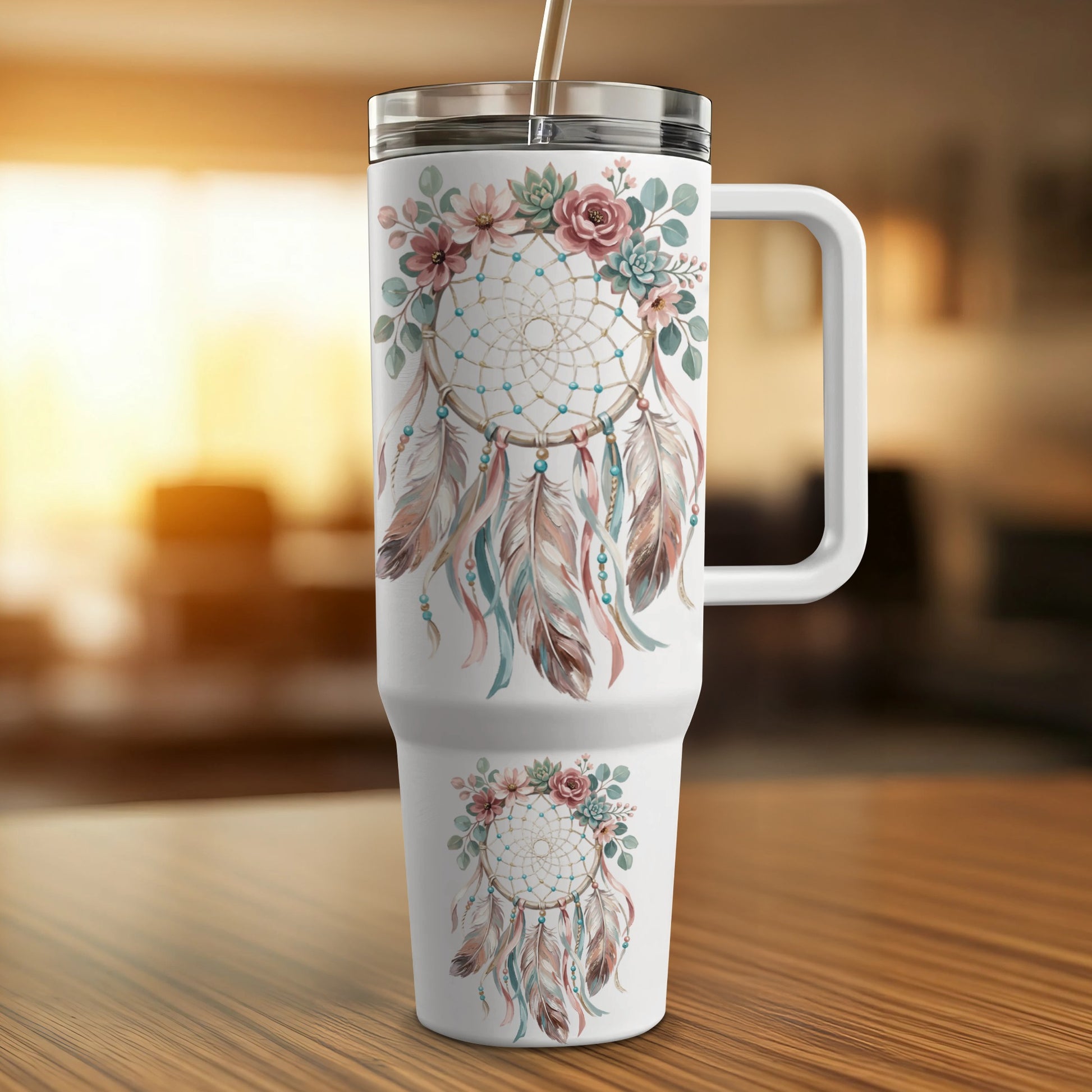 Floral dreamcatcher tumbler with straw on a wooden surface.