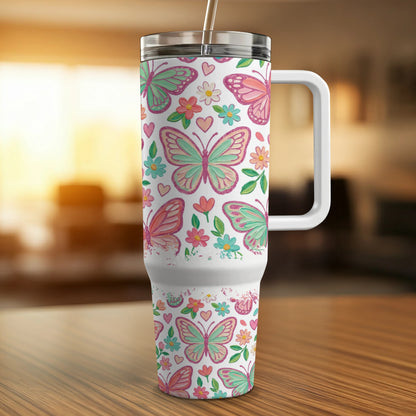 White tumbler with colorful butterfly and floral pattern, and a straw.