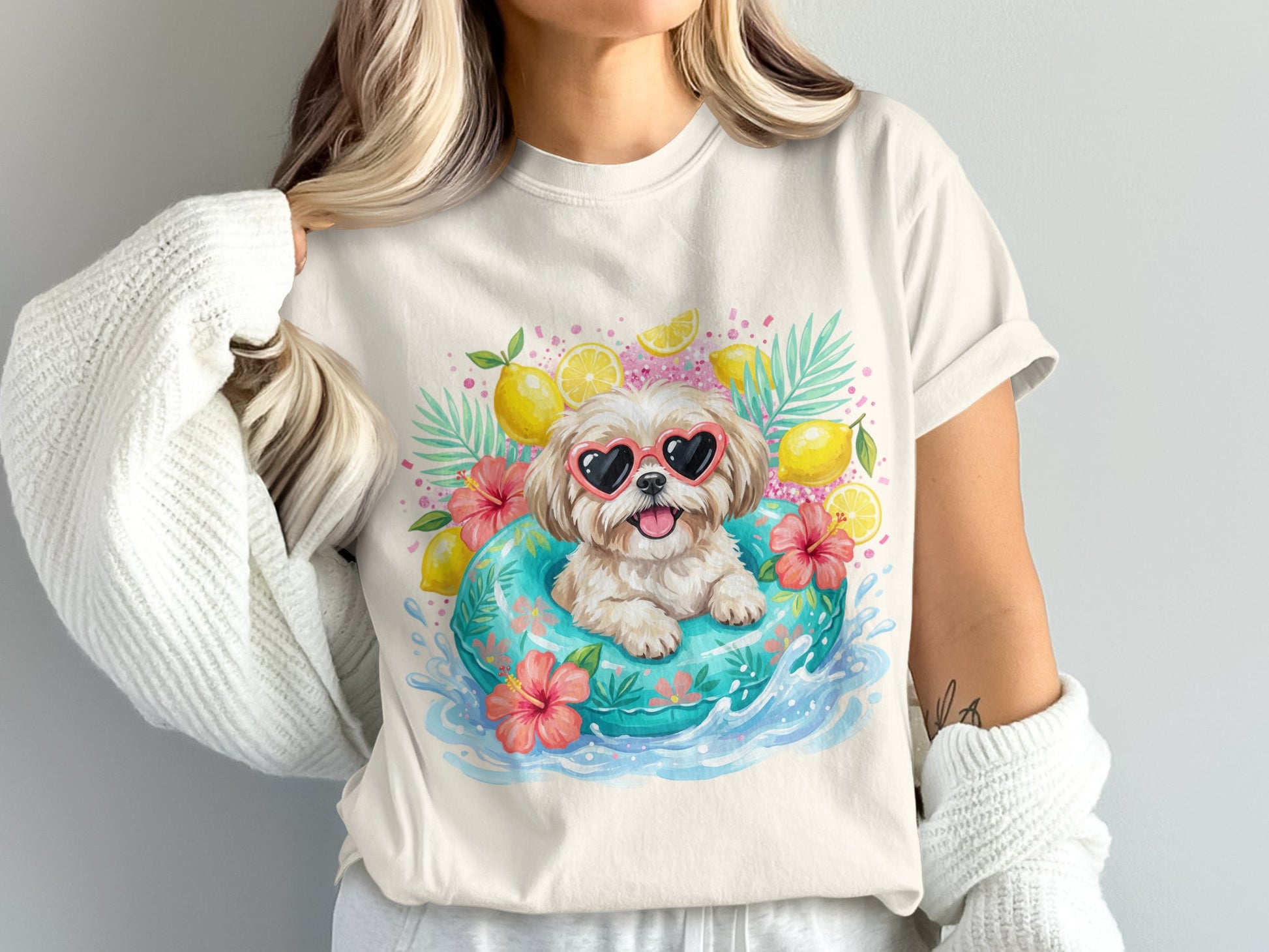 White t-shirt with a dog in a pool float surrounded by lemons and flowers.