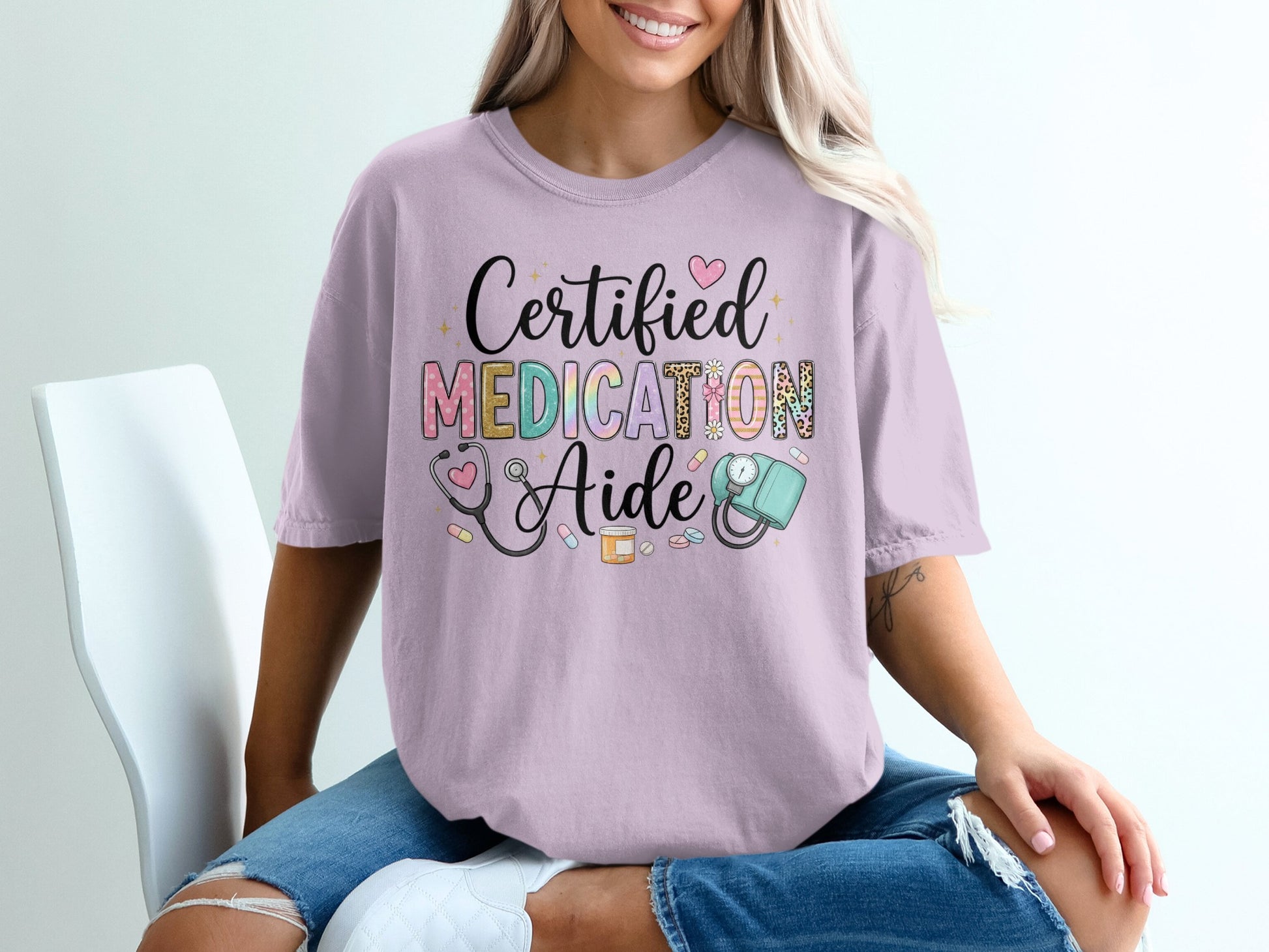 "Certified Medication Aide" text on a lavender t-shirt with medical icons.