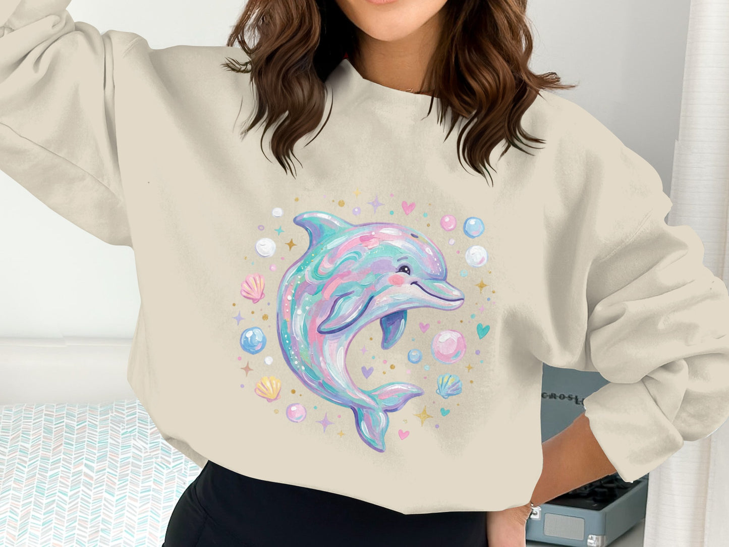 Cartoon dolphin with shells and bubbles on a pastel sweatshirt.