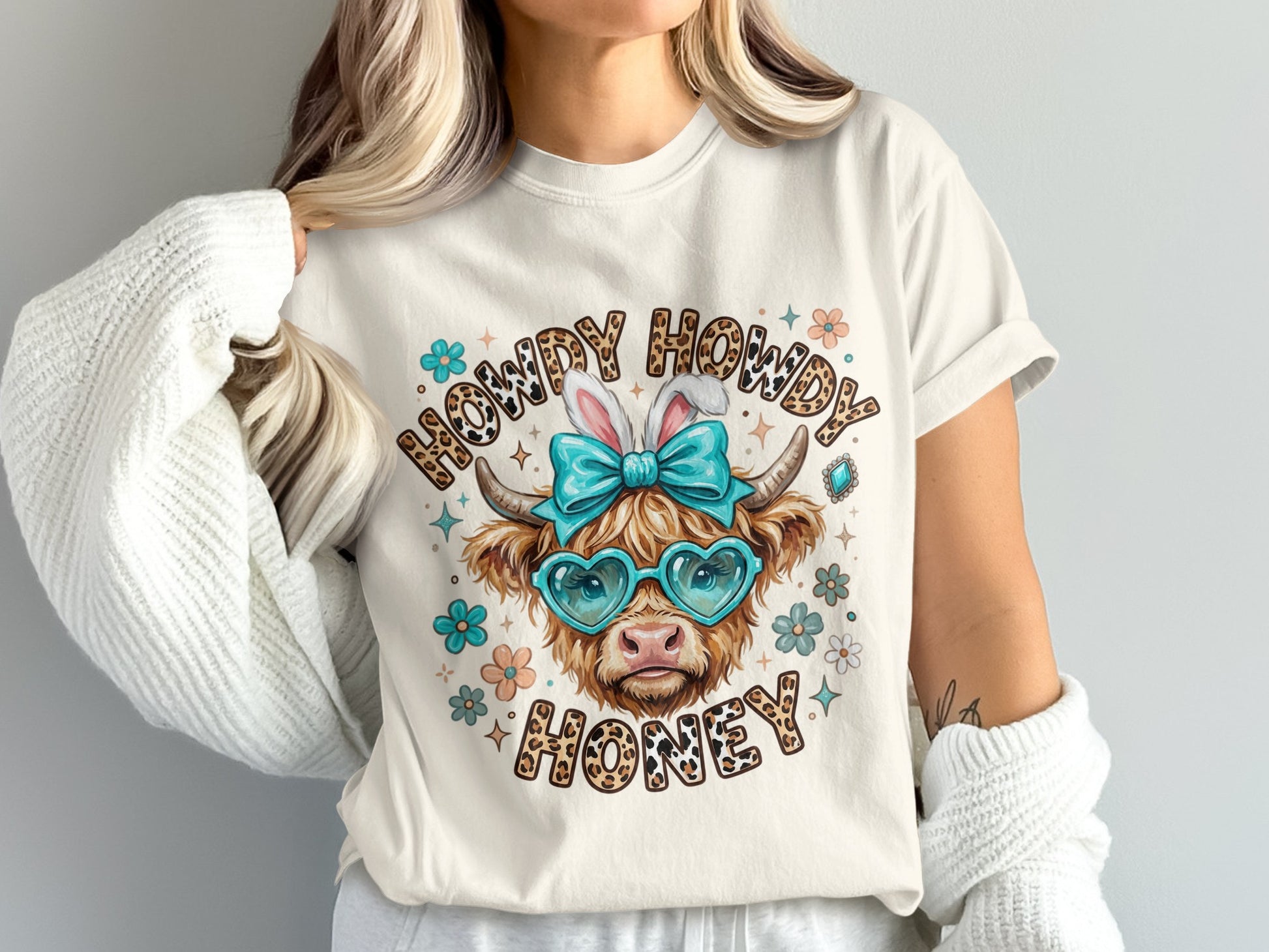 Cow with bunny ears and heart sunglasses, wearing a shirt that says "Howdy Howdy Honey."