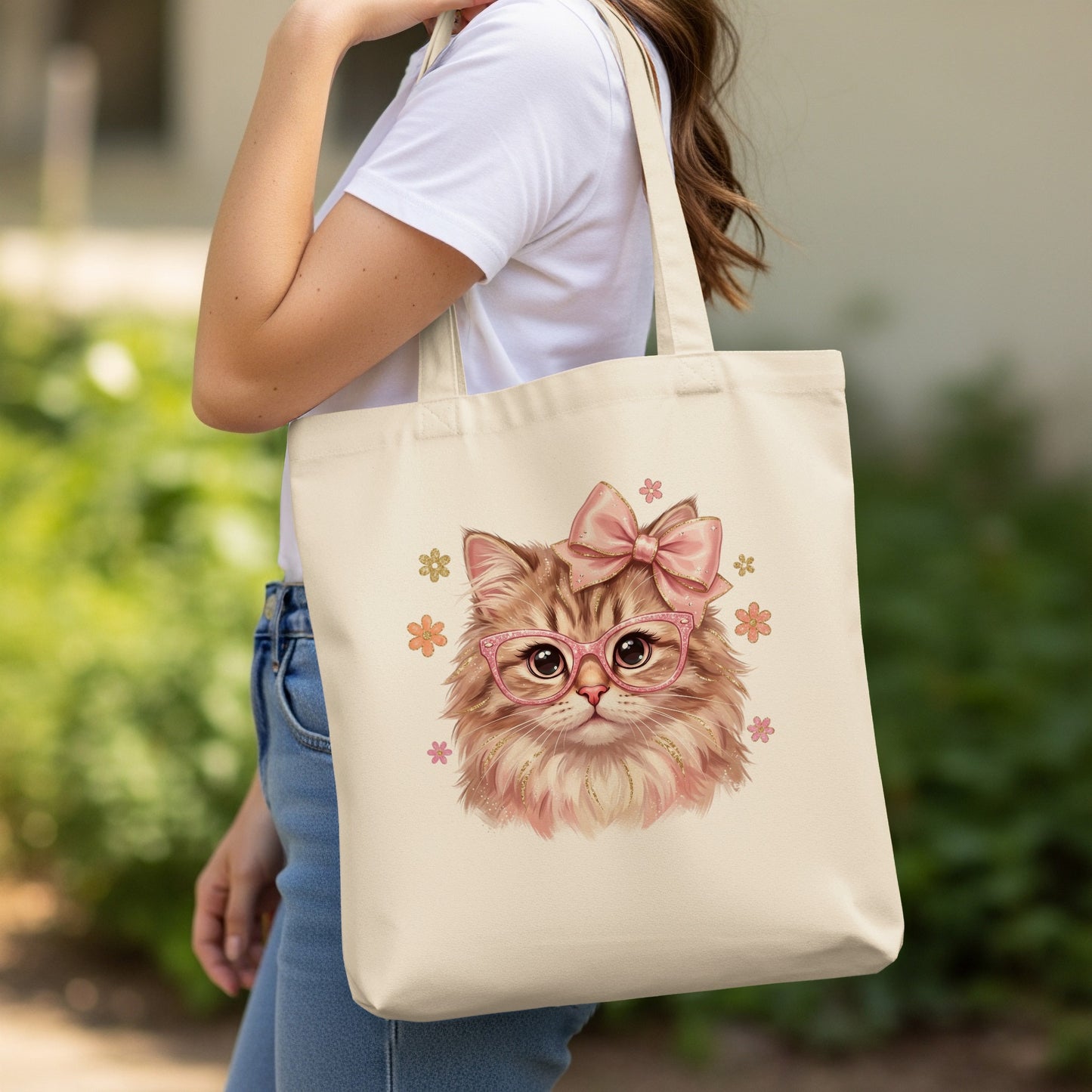 Beige tote bag with pink cat illustration wearing glasses and a bow.