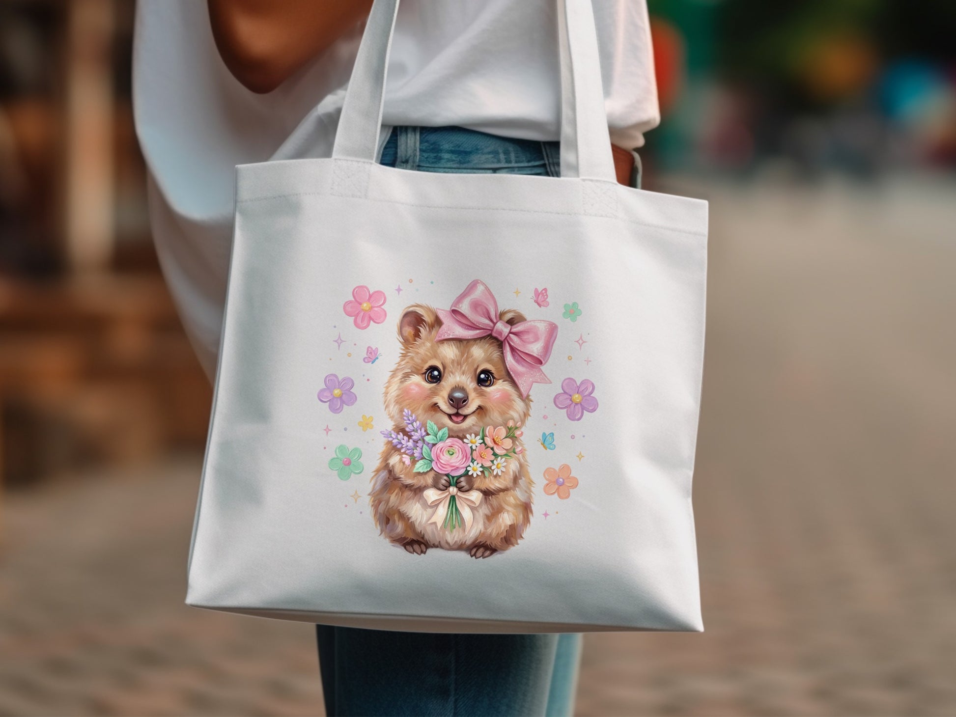 White tote bag with a quokka illustration holding flowers and wearing a pink bow.