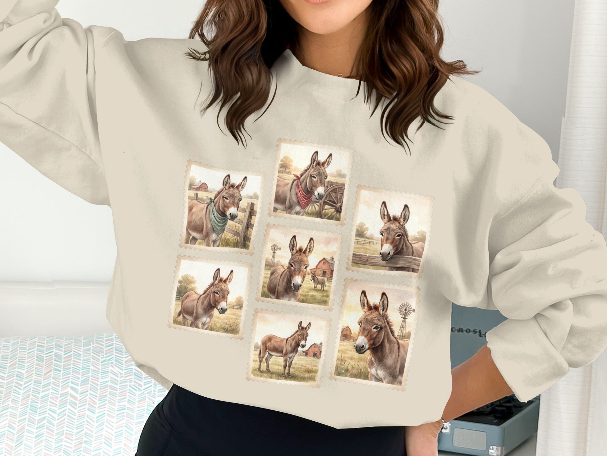 Crewneck sweatshirt with seven postage stamp-style illustrations of donkeys on a farm.