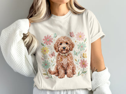 Cream t-shirt with a watercolor doodle dog surrounded by flowers and butterflies.