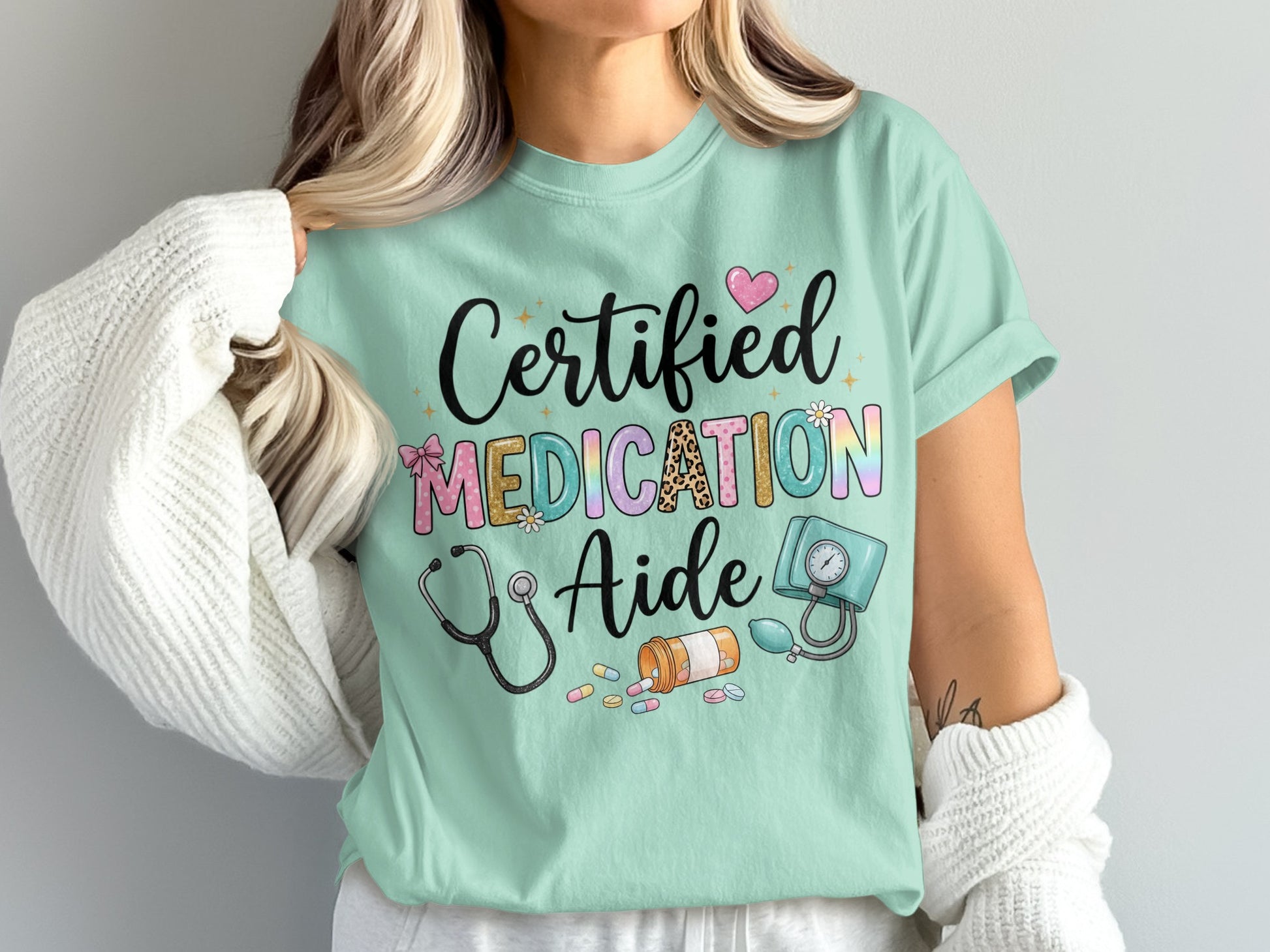 Mint t-shirt with "Certified Medication Aide" text and medical illustrations.