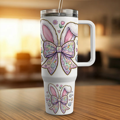 White tumbler with pink Easter bunny ears, bow, and decorated eggs.