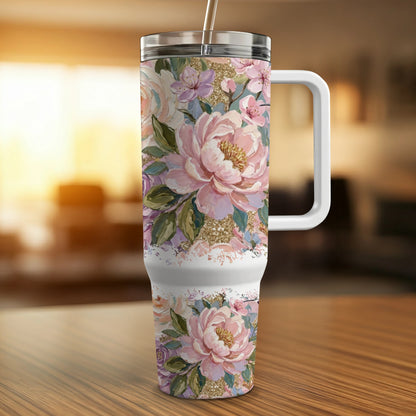 Floral patterned tumbler with handle on a wooden surface.