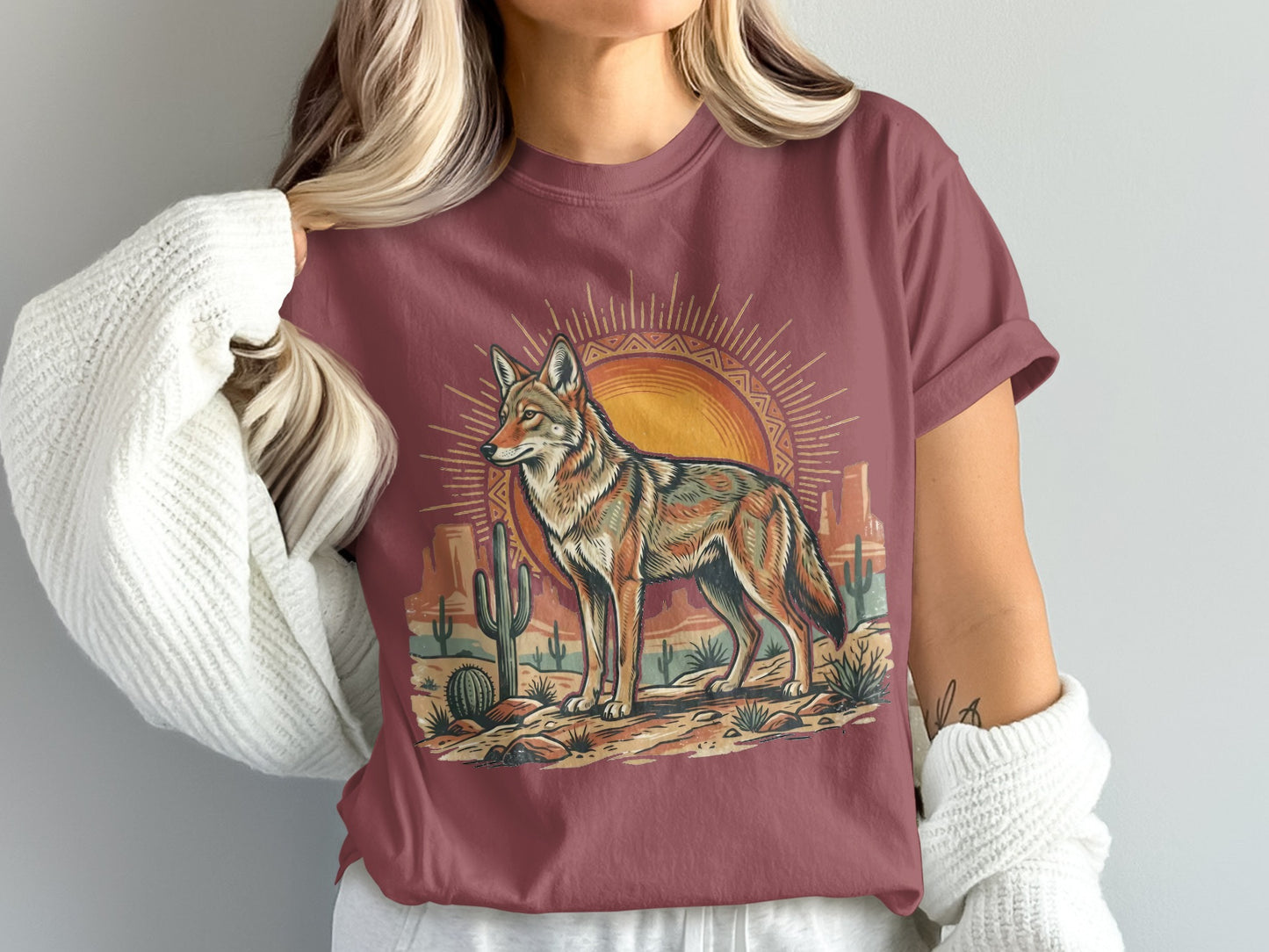 Coyote standing in desert landscape with sunburst and cacti.