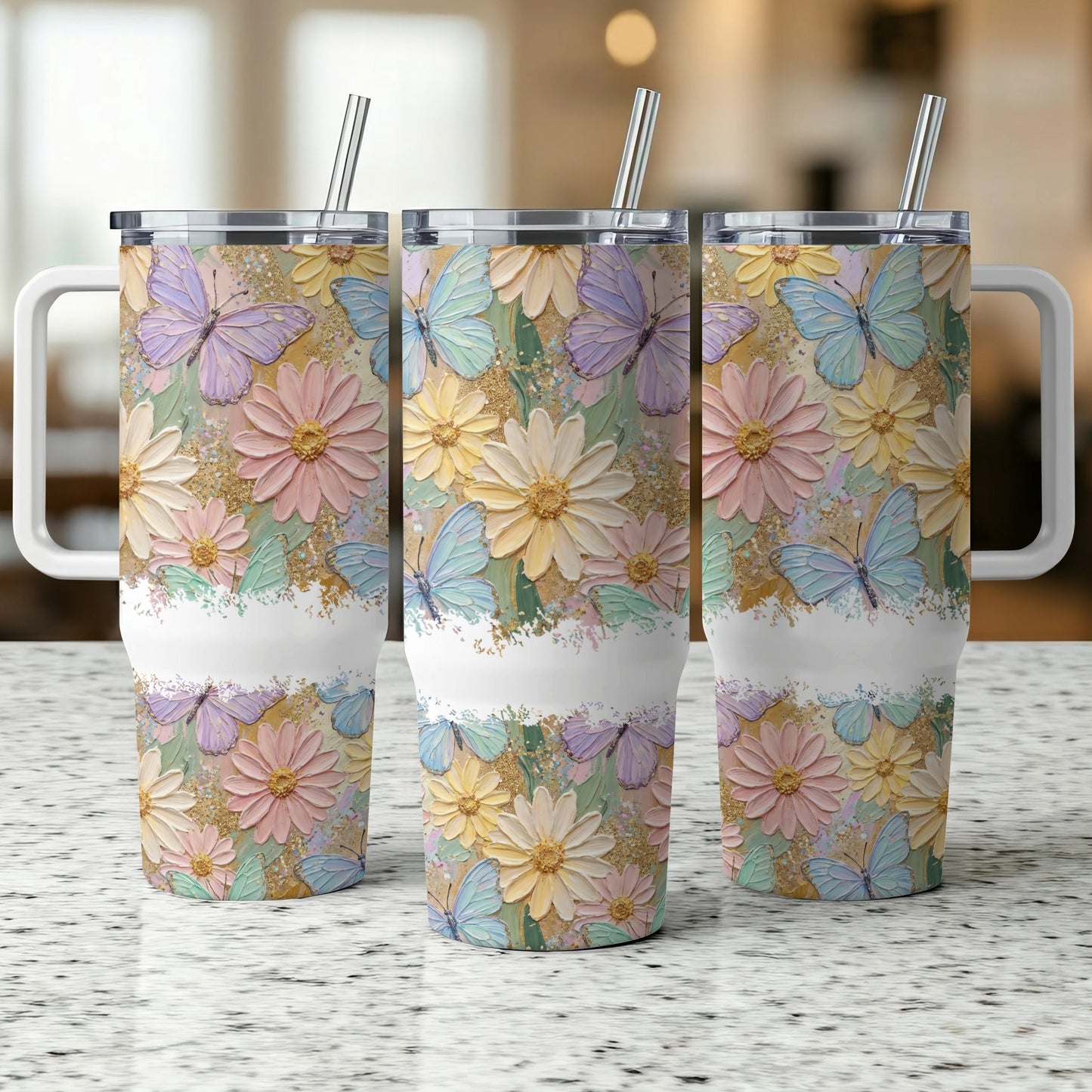 Three tumblers with pastel floral and butterfly designs, standing on a speckled countertop.