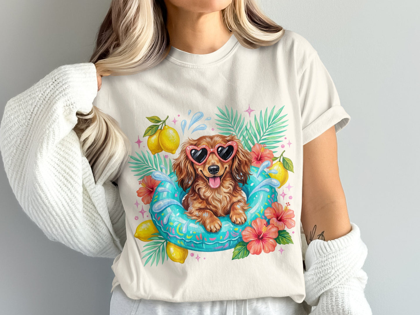 Dachshund wearing heart sunglasses floats in inner tube with lemons and flowers.