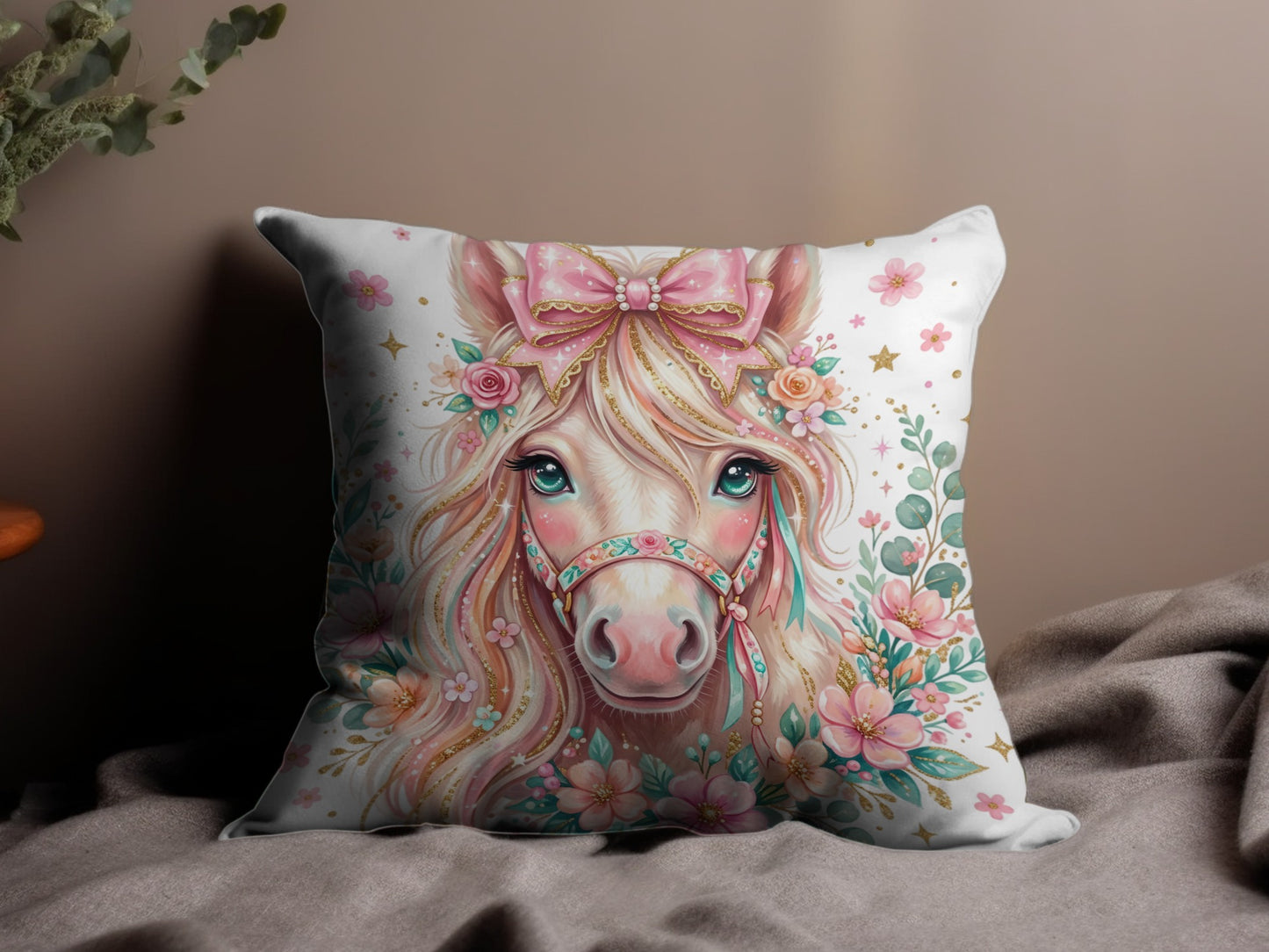 Pillow with a pink unicorn adorned with flowers and a bow.