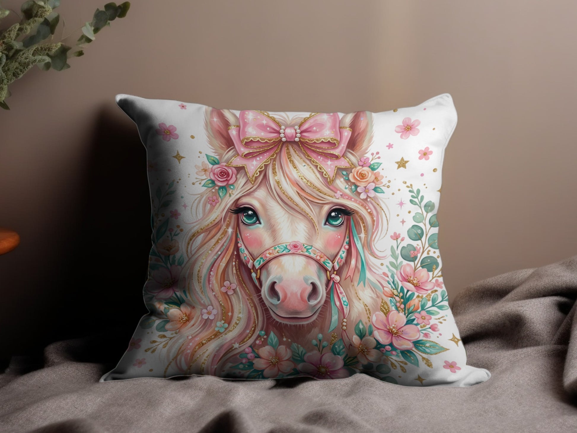 Pillow with a pink unicorn adorned with flowers and a bow.