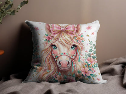 Pillow with a pink unicorn adorned with flowers and a bow.