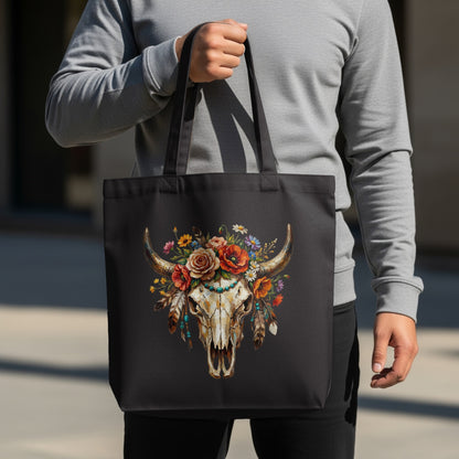 Black tote bag with a bull skull adorned with colorful flowers and feathers.